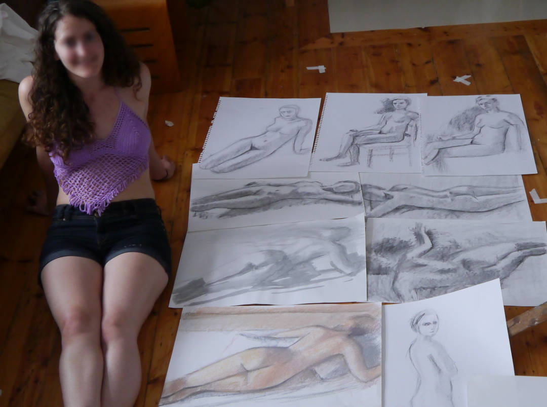 life model sitting next to life drawings