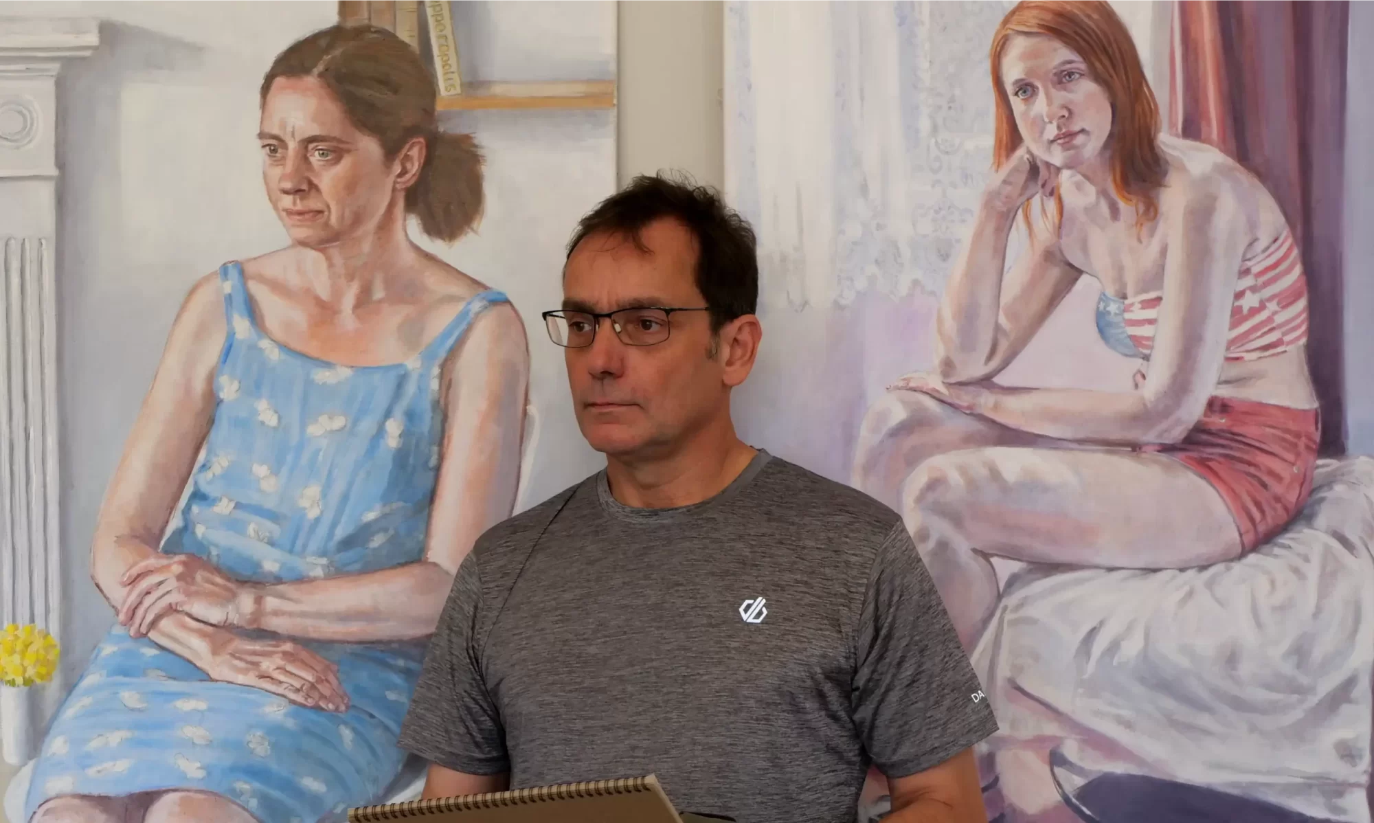 portrait artist Peter D'Alessandri in front of two large portrait paintings