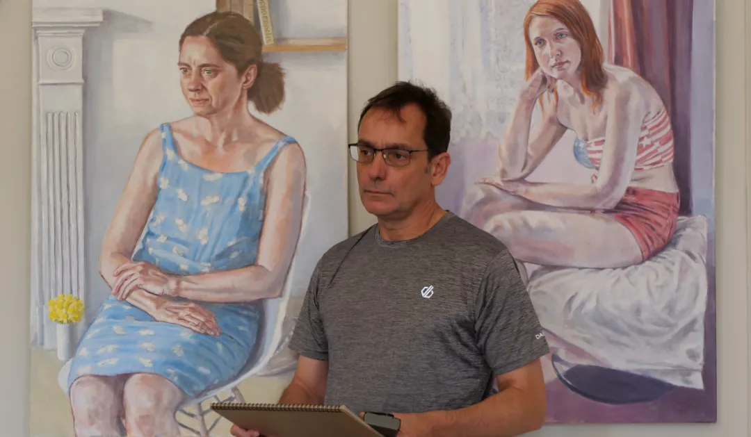 portrait artist Peter D'Alessndri infront of his two large portrait paintings